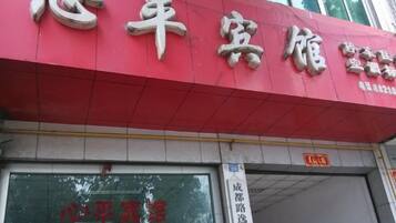 A red building with a sign that reads '心平客栈' and a partially visible door.