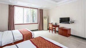 A hotel room with two beds, a desk, a television, and a minibar. - Xinping Hotel (Dayi)