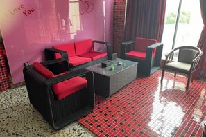 Una habitación con una decoración en rojo y negro, que incluye un sofá, una silla y una mesita de centro.