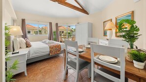 Ein Schlafzimmer mit Bett, Nachttisch, Lampe und Blick ins Freie.