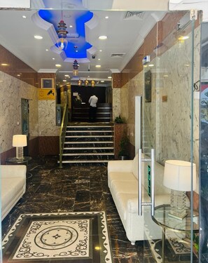 Experience the stylish lobby with a decorative marble floor, staircase, and seating areas.