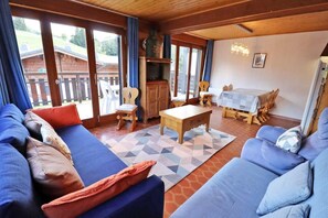 Una sala acogedora con un conjunto de sofá, una mesa de centro de madera y una mesa de comedor con sillas.
