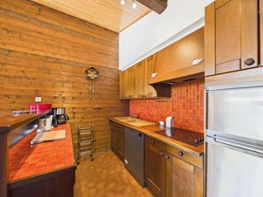 A kitchen with wooden cabinets, a stainless steel refrigerator, and a red tiled backsplash. - 200m from ski slopes, 3rd floor, balcony, fireplace or stove, ski locker, 100m², Les Gets (Les Gets)