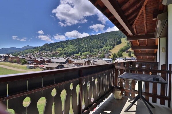 A balcony with a view of a village and mountains.