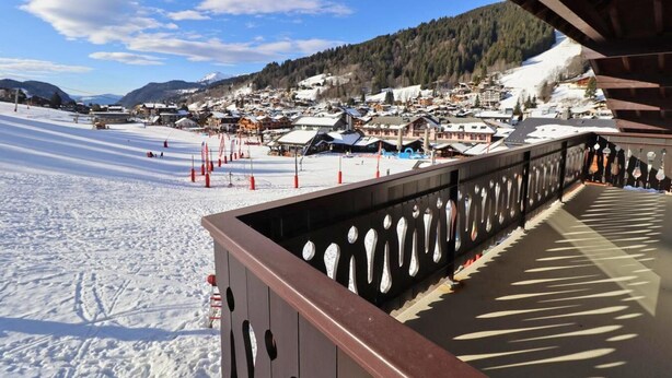 Una stazione sciistica innevata con un pontile in legno che si affaccia sul paesaggio.