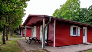 A red cabin with a picnic table and grill outside. - Bernsteinland Barth (Barth)
