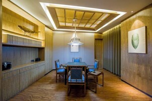 Un comedor moderno con una mesa de madera, sillas e iluminación colgante.