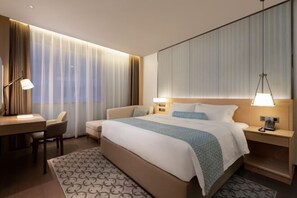 A modern hotel room with a large bed, bedside tables with lamps, a desk, and a chair. - Xuanhan JUNLIN·HOTEL Junlin Hotel (Baren Square Branch of Xuanhan County People's Hospital) (Xuanhan)