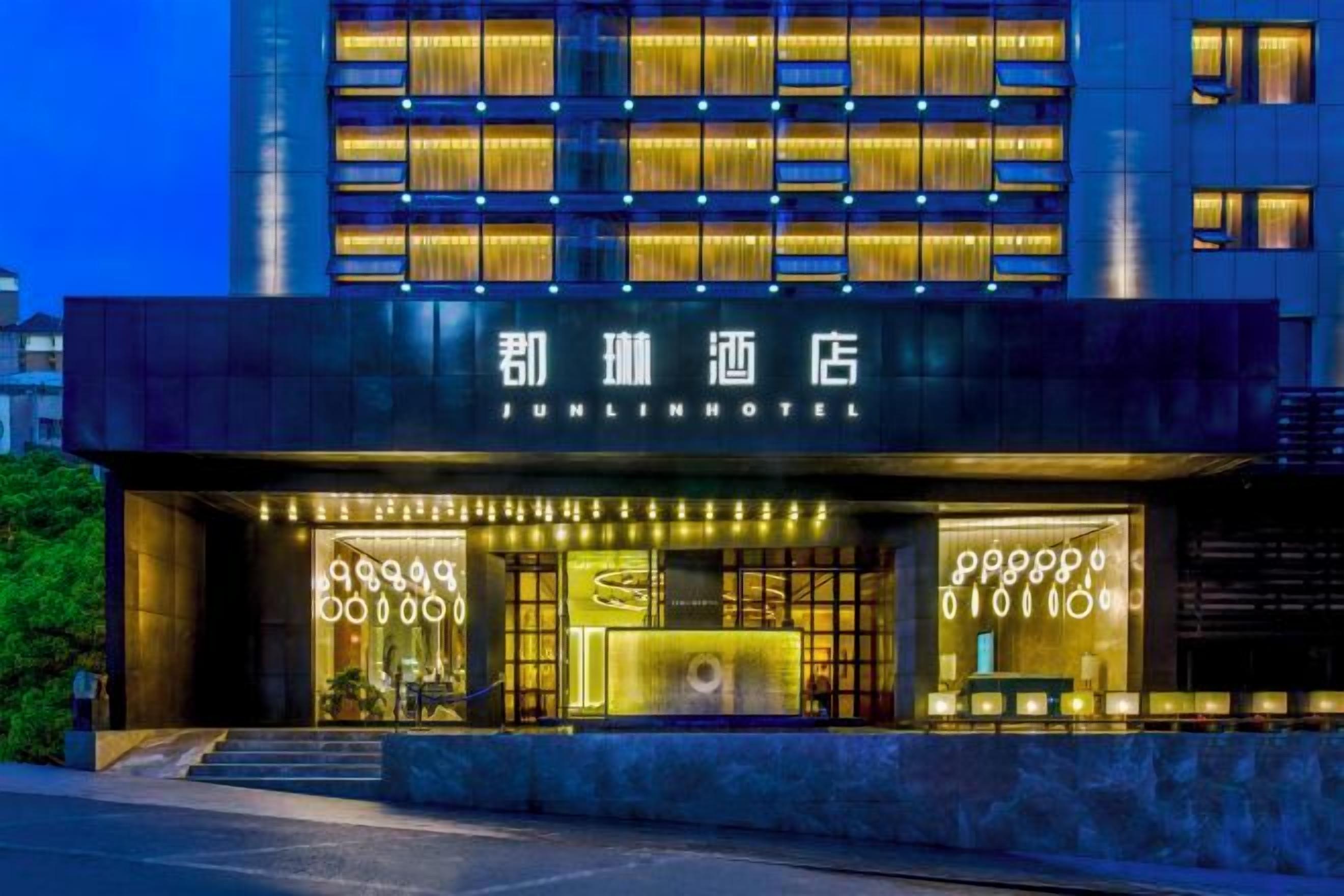 Ein Hotel mit moderner Fassade, beleuchteter Beschilderung und einem gut ausgeleuchteten Eingang.