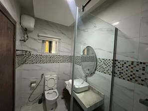 Un baño con inodoro, lavabo y zona de ducha.