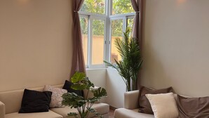 Ein modernes Wohnzimmer mit zwei Sofas, einem Couchtisch und einer Topfpflanze.
