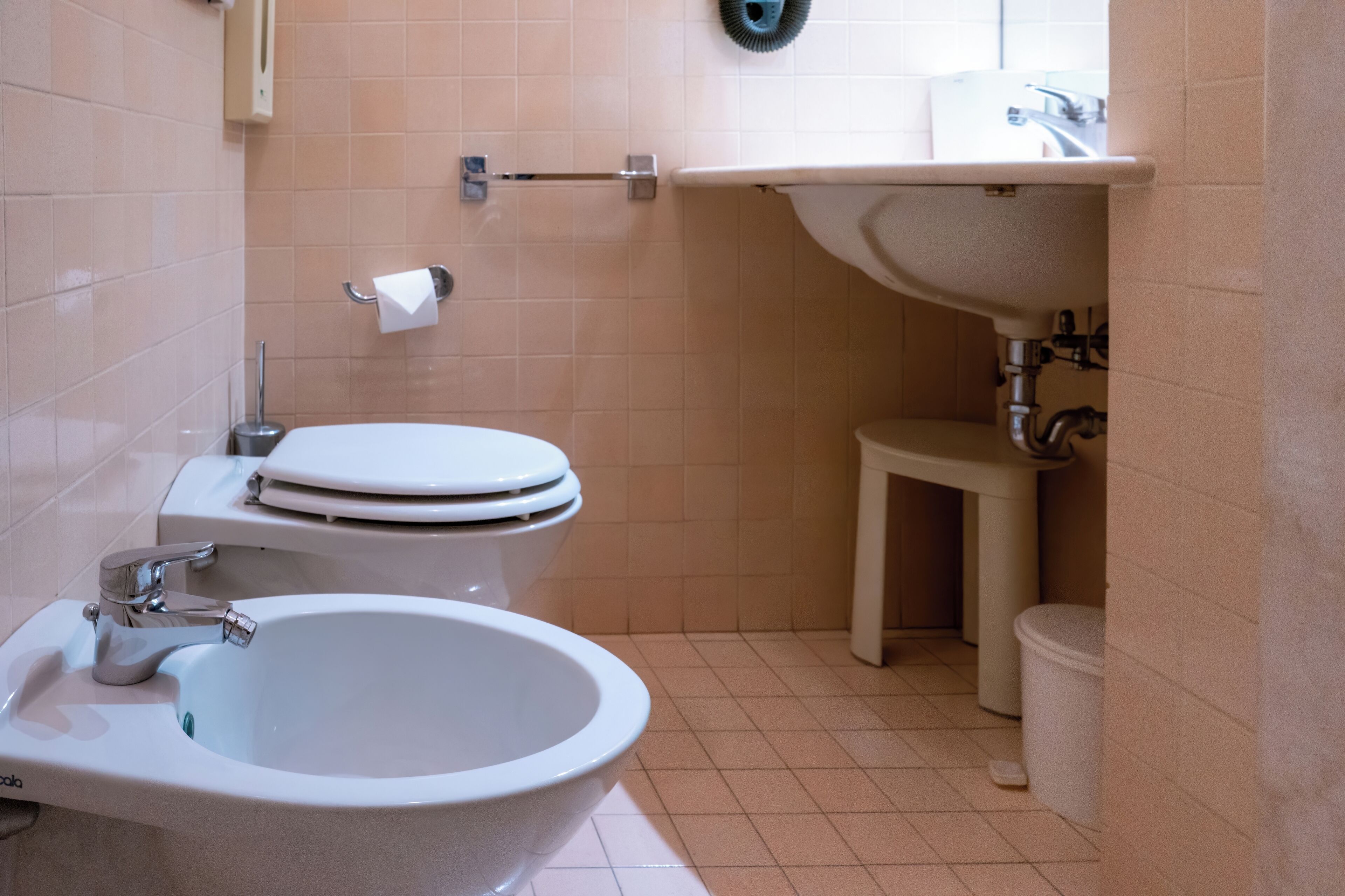 A bathroom with a toilet, bidet, and sink.