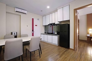 A compact kitchen with a refrigerator, stove, and cabinets. - Favehotel Nagoya - Batam (Nagoya)