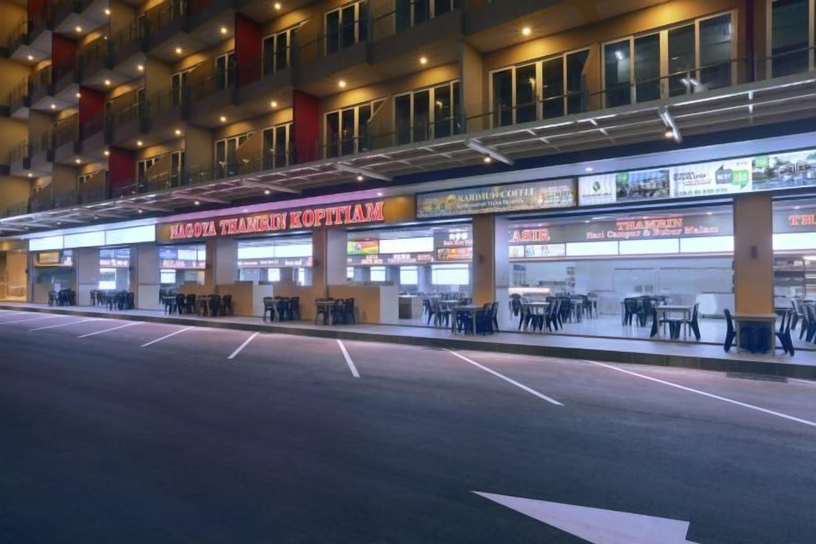 A building with multiple shops on the ground floor, including a restaurant named "KAROVA TEAMIN KOPITIAM".