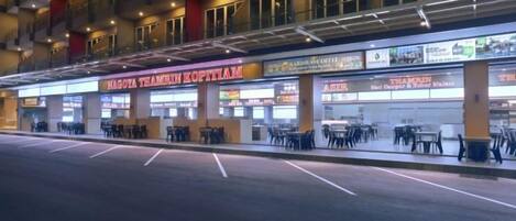 A building with multiple shops on the ground floor, including a restaurant named "KAROVA TEAMIN KOPITIAM".