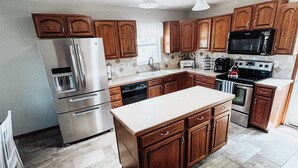 Une cuisine moderne avec des meubles en bois, des appareils en acier inoxydable et un îlot central.