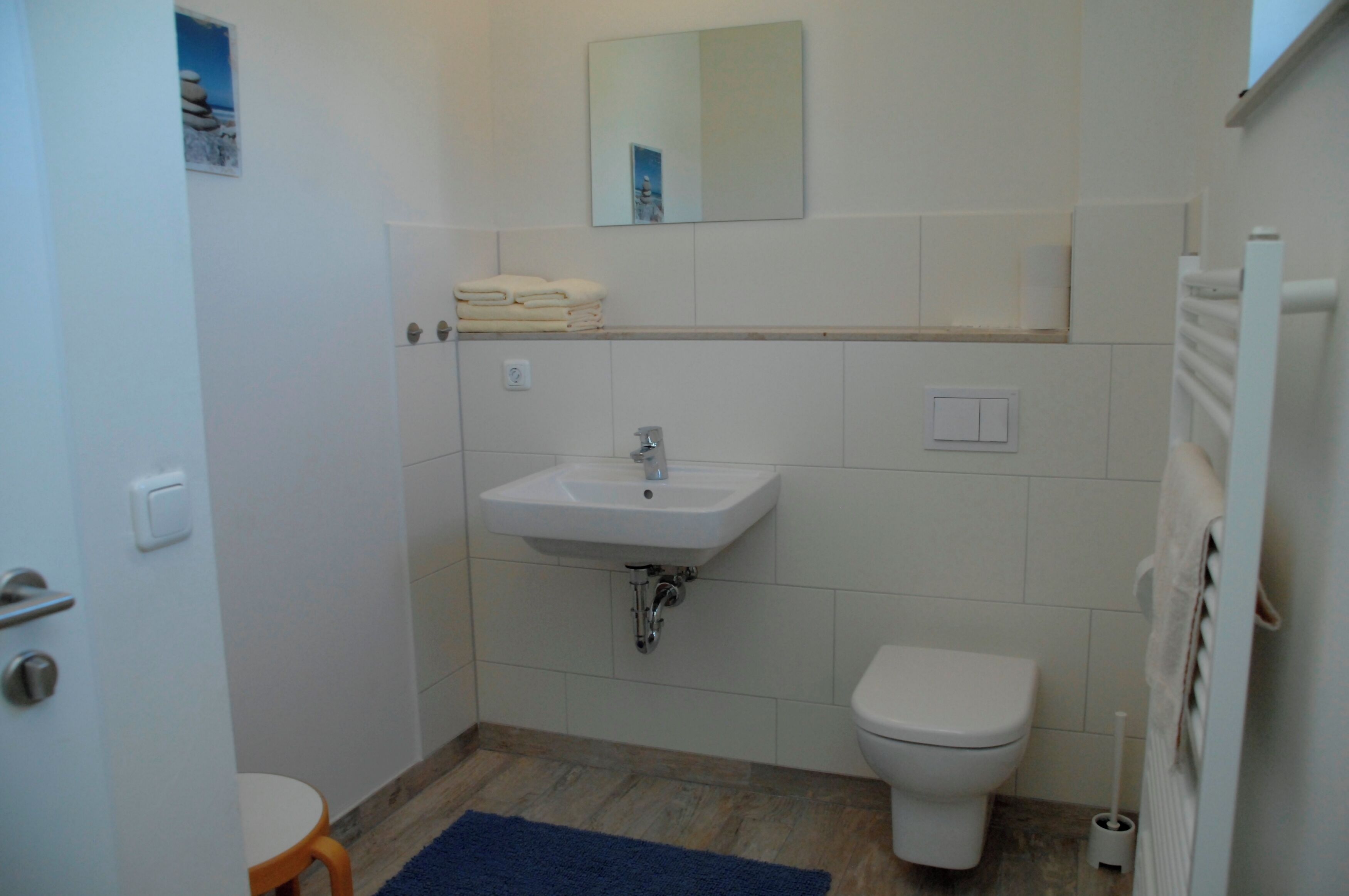 Une salle de bain avec un lavabo, des toilettes et un miroir au-dessus du lavabo.