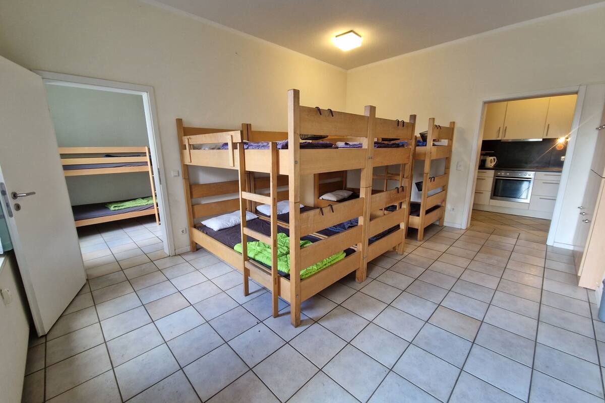 Um quarto com beliches, cozinha e banheiro.