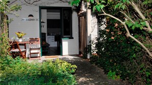 Un petit bâtiment blanc avec une porte verte et une enseigne indiquant « Trakfenn 18 ».