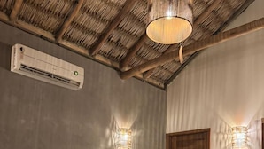 A bedroom with a bed, a wooden headboard, an air conditioning unit, and two wall-mounted lights. - Pacas Suítes (Santo Amaro do Maranhão)