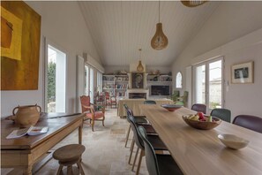 Relax in this spacious living area with a dining table, bookshelf, and large window.
