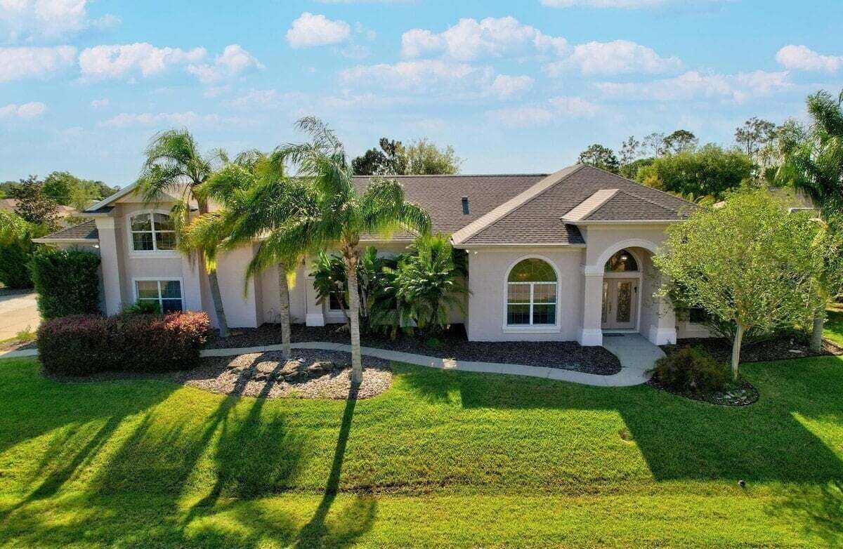 A two-story house with a front porch, a garage, and a well-maintained lawn.