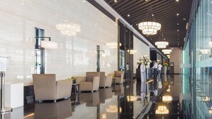 A modern lobby with reflective floors, seating areas, and large pendant lights. - GemstoneBR II in SMDC Air Residences (Makati)