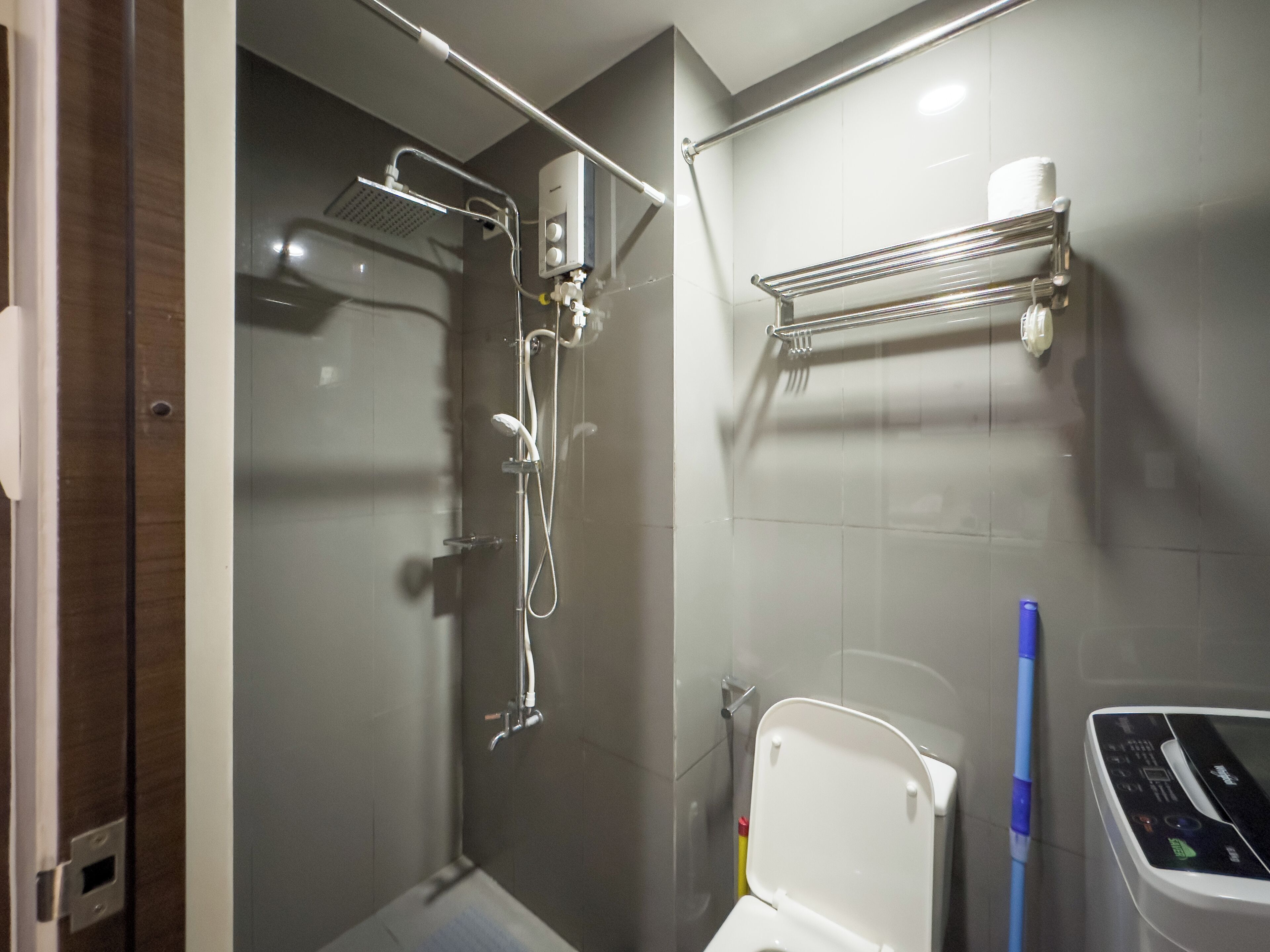Un bagno moderno con cabina doccia in vetro, un water e un asciugamani ad aria.