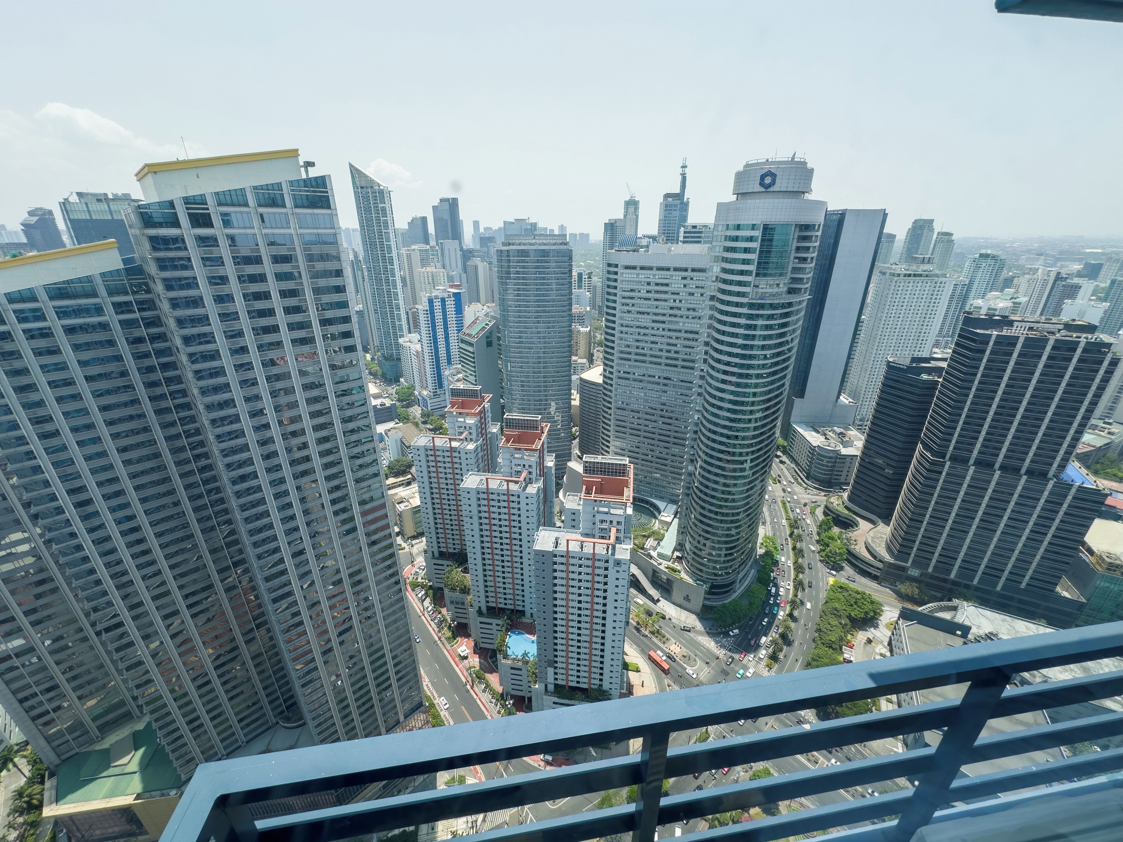 A high-rise urban cityscape with modern architecture, including a variety of building designs and a busy street below.