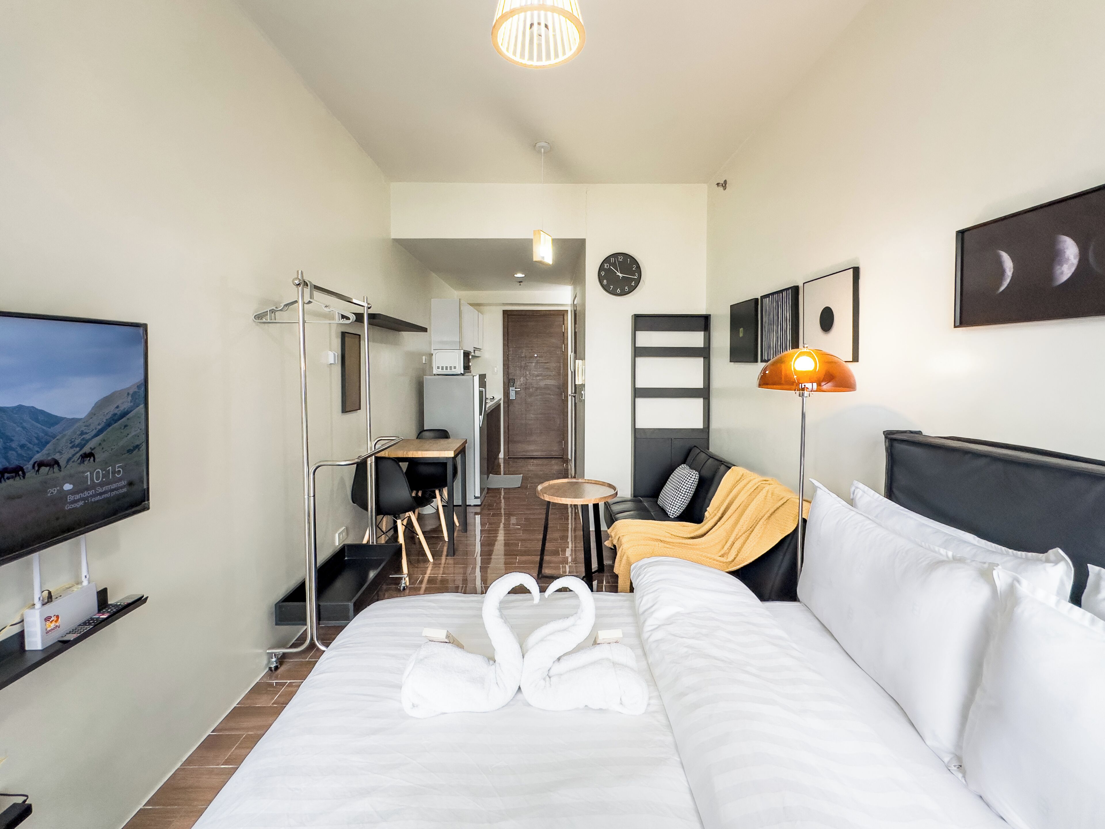 A hotel room with a bed, a TV, a desk, and a sofa.