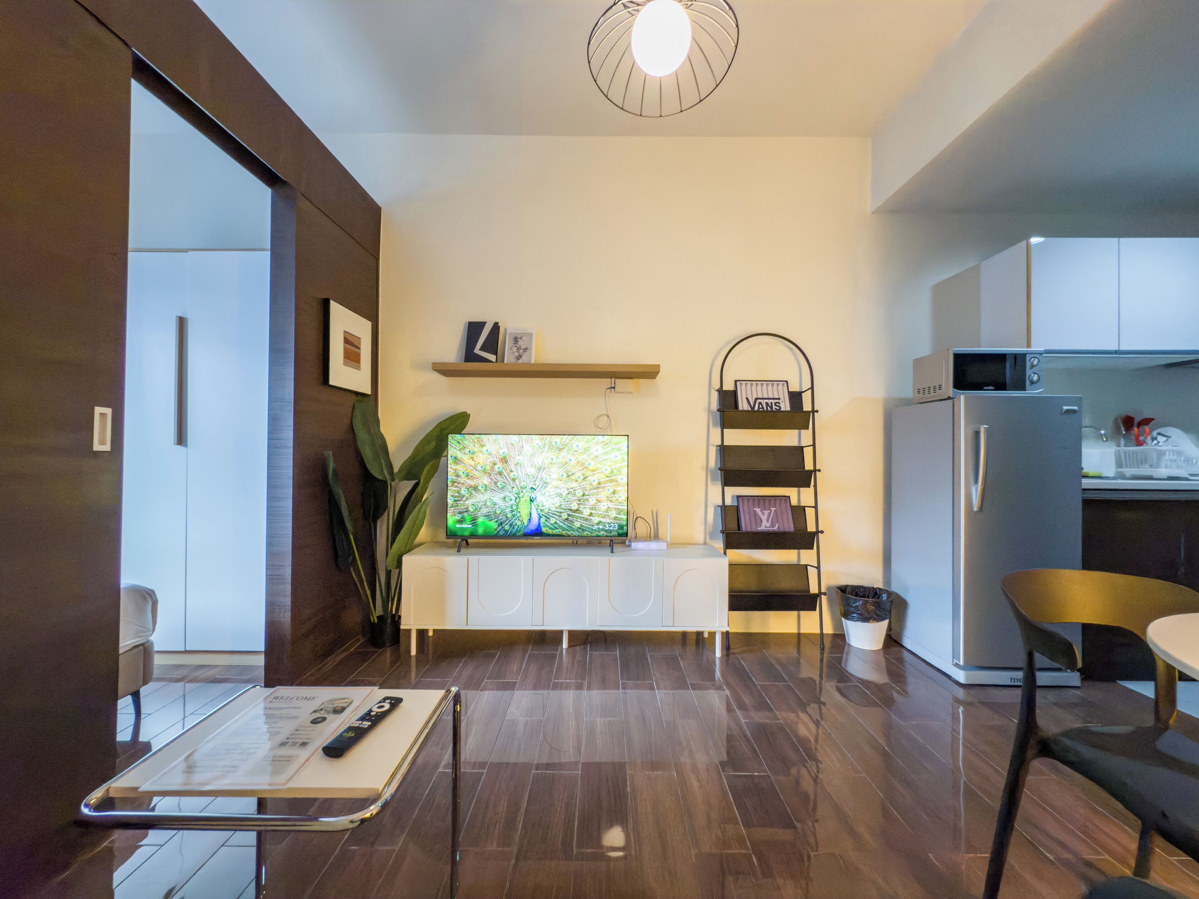 Una cocina moderna con microondas integrado, refrigerador y comedor con mesa y sillas.