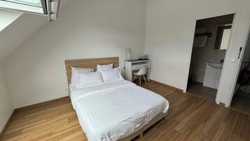 Une chambre à coucher avec un lit, un bureau et une salle de bain.
