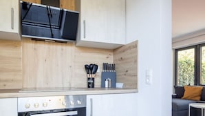 Eine moderne Küche mit weißen Schränken, einem eingebauten Backofen und einer Holzarbeitsplatte.