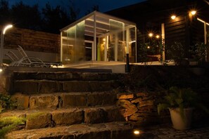 A modern building with a glass enclosure, stone steps, and outdoor lighting. - Spera Luxury Palermo (Monreale)