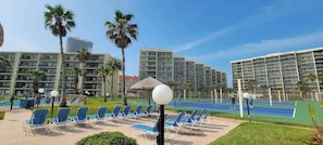 Un hôtel composé de plusieurs immeubles de grande hauteur, doté d’une piscine et d’espaces extérieurs aménagés avec des chaises et des parasols.
