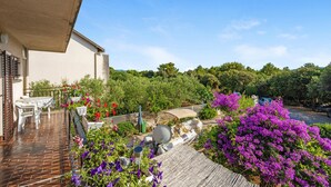 A patio with a table and chairs, surrounded by vibrant flowers and a satellite dish. - Nice apartment in Sibenik with WiFi (Sibenik)