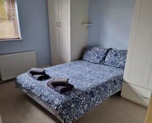 Une chambre à coucher avec un lit, une armoire et un radiateur.