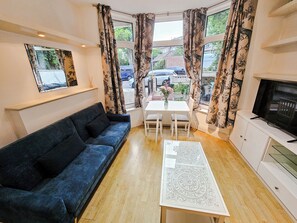 Une chambre meublée avec un canapé, une table à manger et un téléviseur.