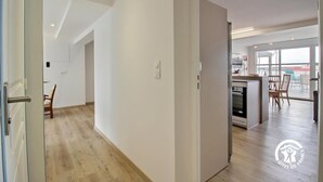 Un appartement moderne doté d’une cuisine, d’un coin repas et d’un balcon avec vue.