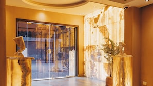 A lobby with marble columns, a staircase, and a seating area. - Almas Pyramids View (Giza)