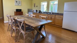 Eine Küche mit Holztisch und Stühlen, einem Kühlschrank und einer Mikrowelle.