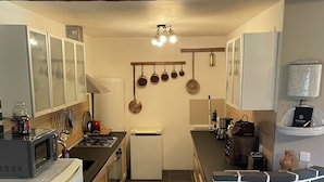 A compact kitchen with a central island, a microwave, a refrigerator, and a sink. - Grand Gîte (Savigny-sur-Braye)