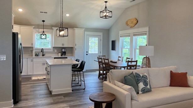 A modern kitchen with white cabinets, a central island, and pendant lighting. - Sound Views! Brand New 3 bedroom (Kill Devil Hills)