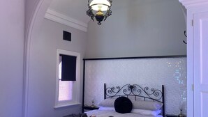Une chambre à coucher avec un lit, une table de chevet, une lampe et une armoire.