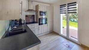 Eine moderne Küche mit schwarzem Arbeitsplatz, Edelstahlgeräten und Holzschränken.