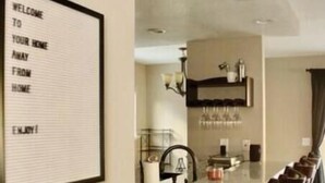 A modern kitchen with a marble countertop, a built-in oven, and a hanging light fixture.