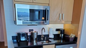 A compact kitchen with a microwave, sink, and dishwasher. - Elara Studio (Las Vegas)