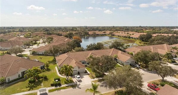 A residential area with houses, a lake, and a clear sky.