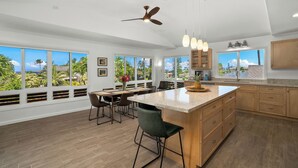 A spacious kitchen with large windows, a central island, and modern cabinetry. - 4Br 4.5 Ba Punahele House with Ocean and Mountain Views, Beach Gear, Near Queens Pond (Princeville)
