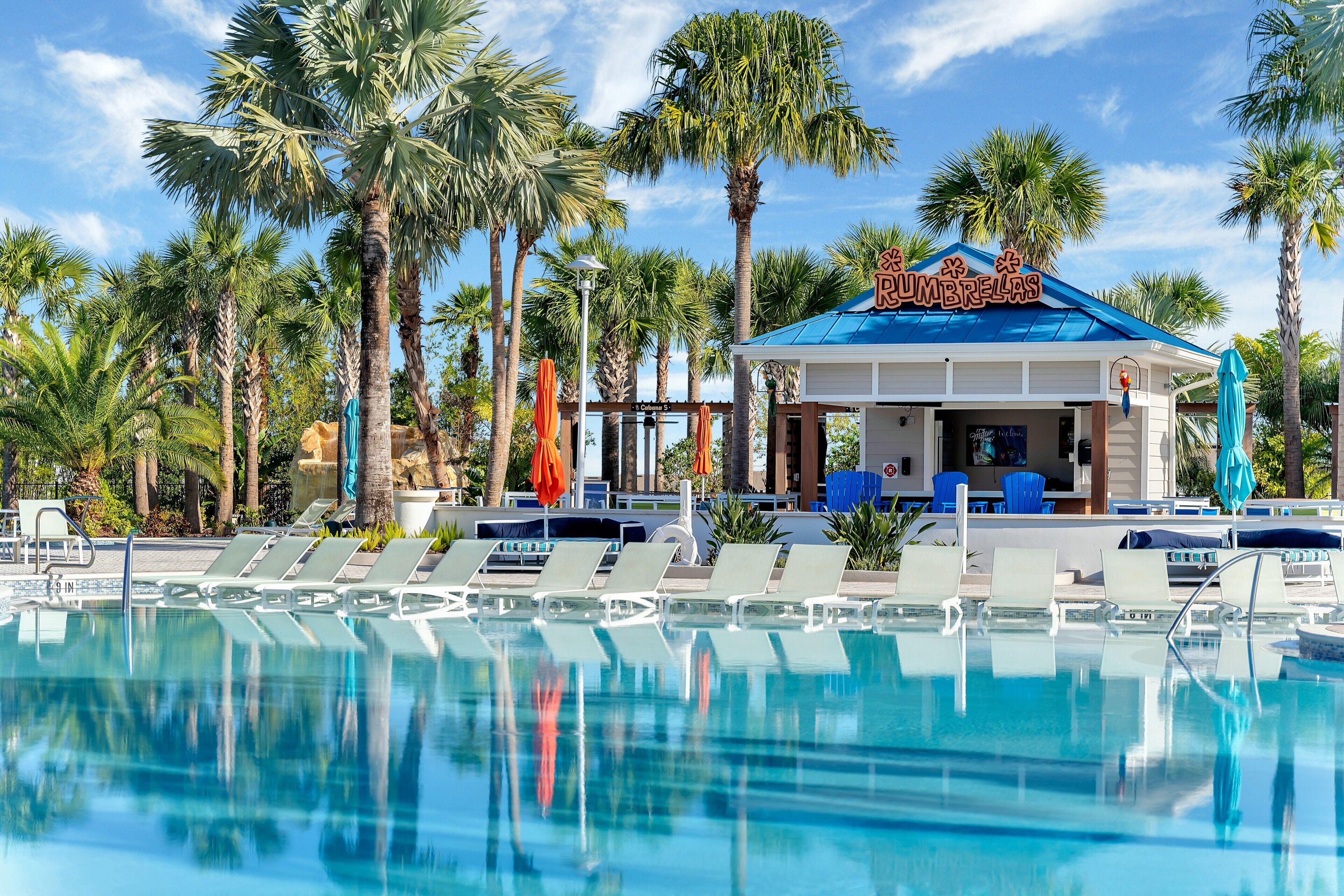 A pool area with lounge chairs and a building labeled "Cumbrecas".